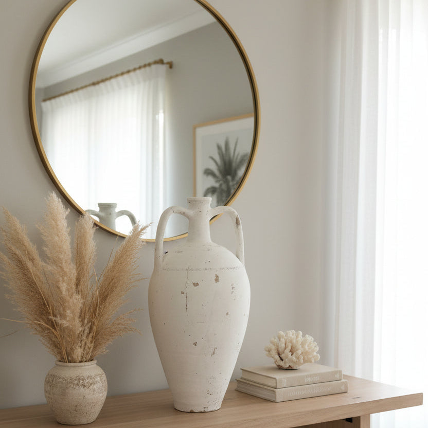 A large distressed white ceramic amphora-style vase with two handles, 