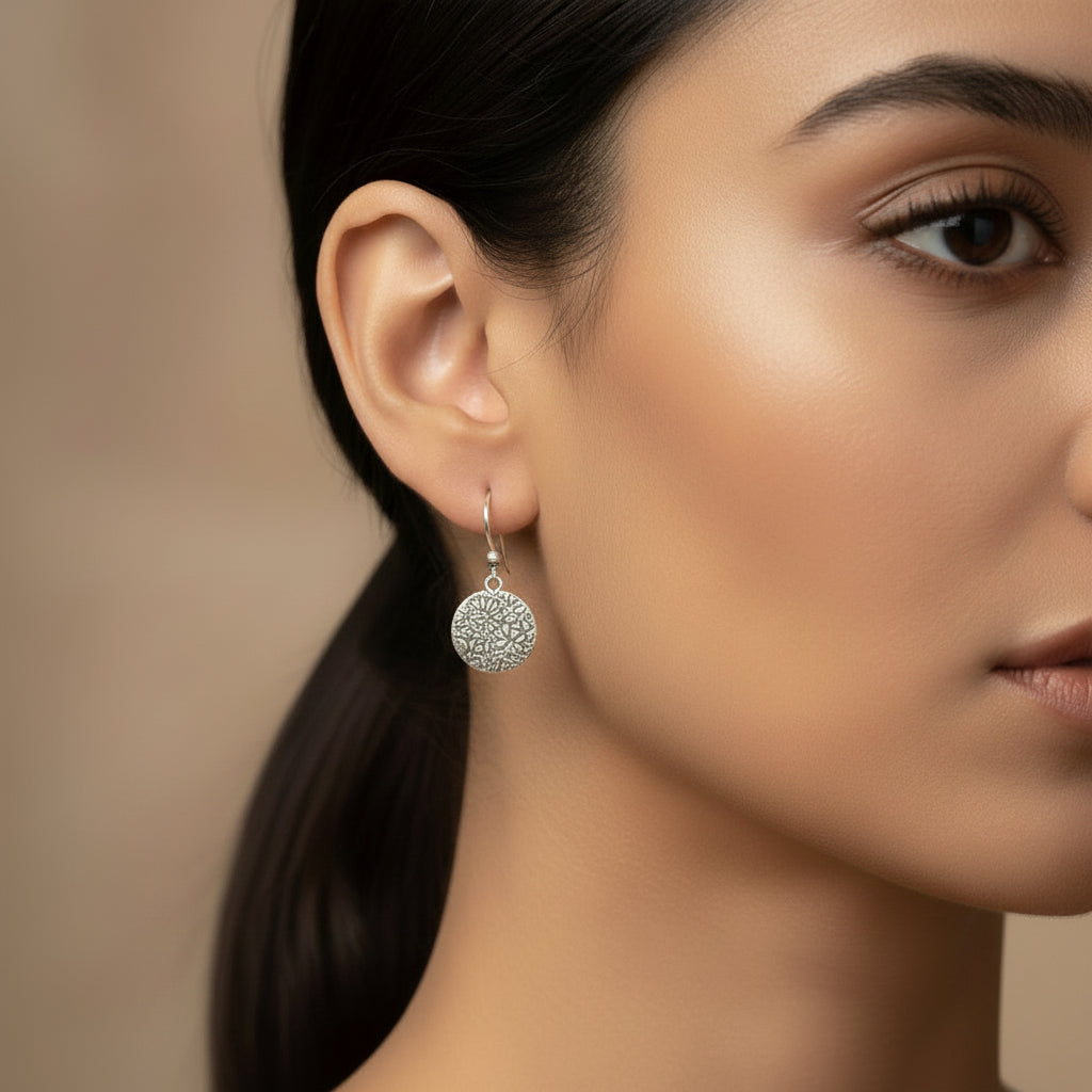 A pair of textured round disk hook earrings in 925 silver that dangle  beautifully.