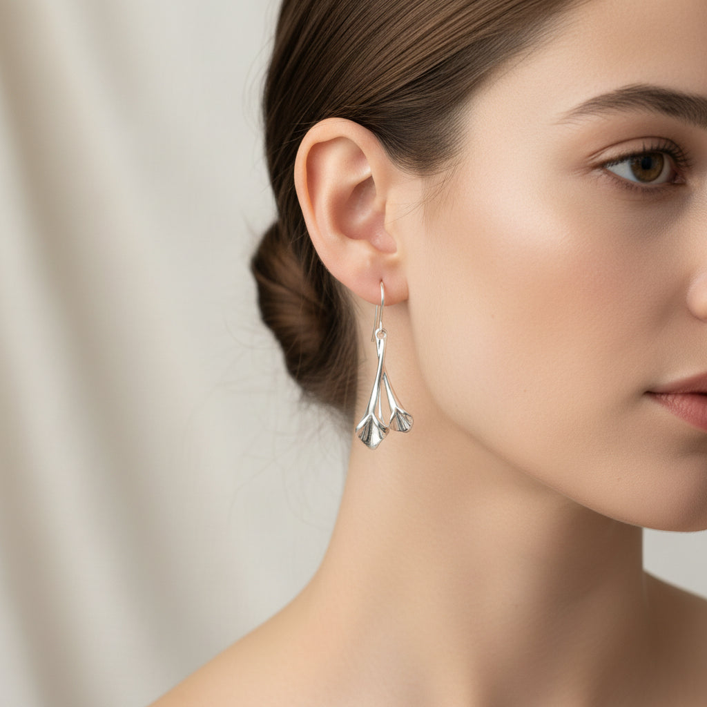 A pair of silver dangling earrings with a textured, organic leaf-like drop design beautiful for any occassion.