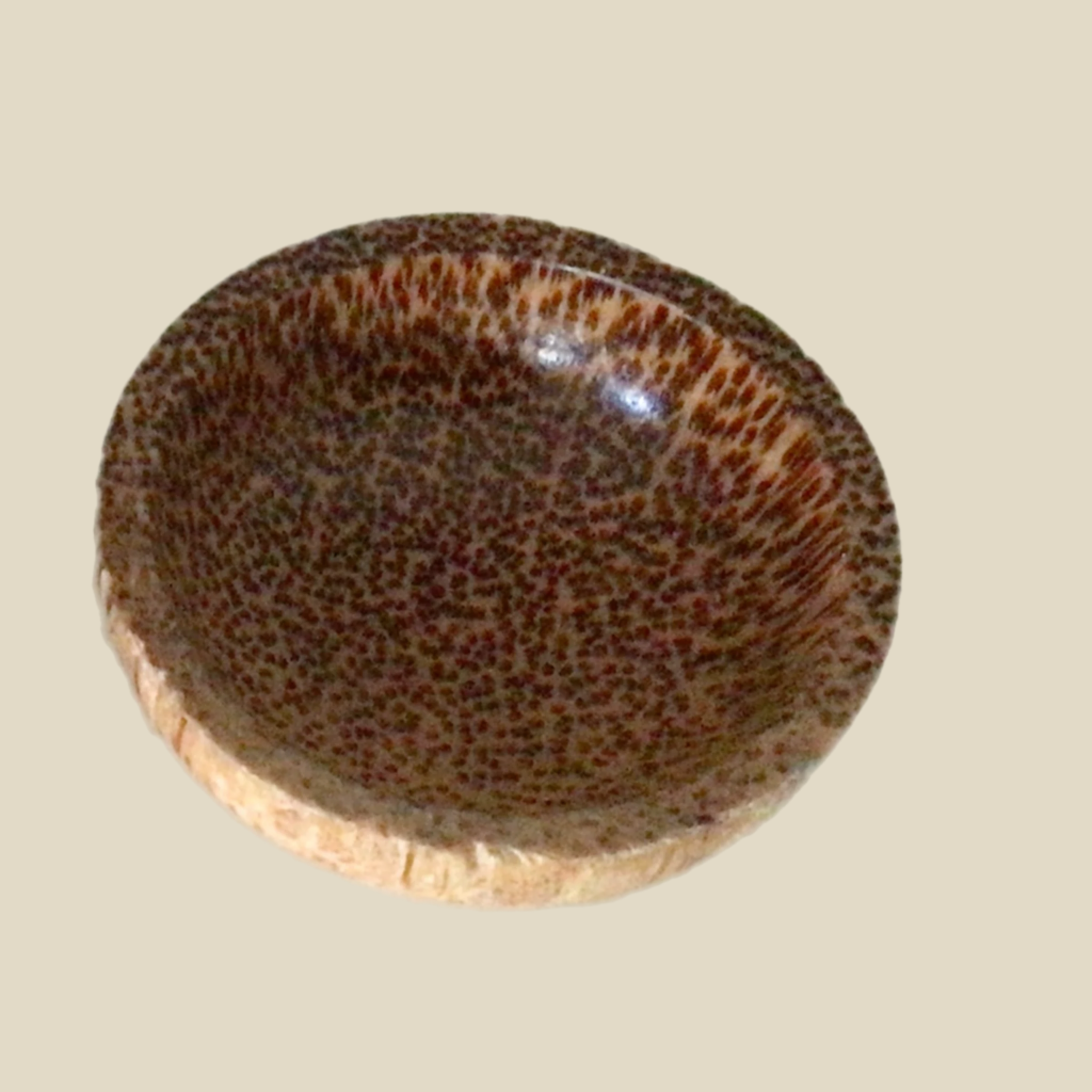 A small wooden bowl with a brown pattern, handmade.